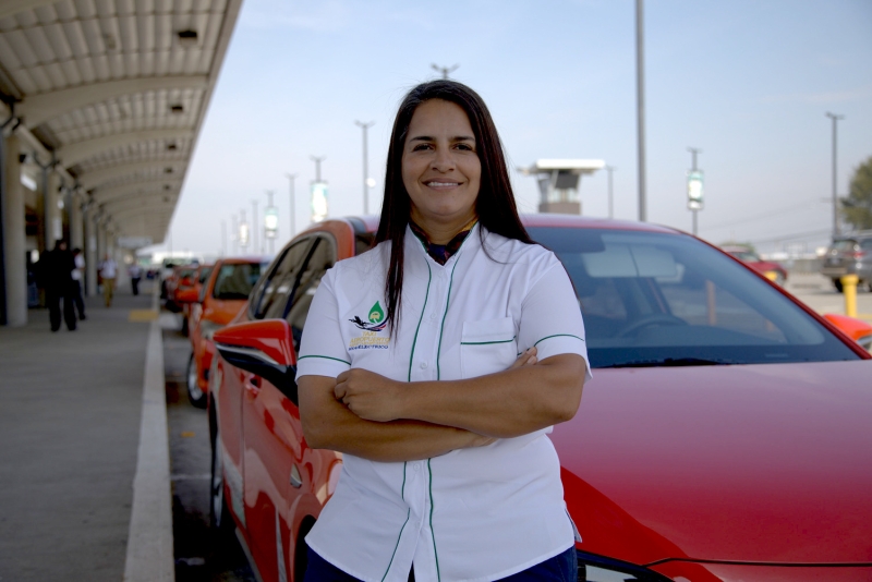 A woman standing beside a red car