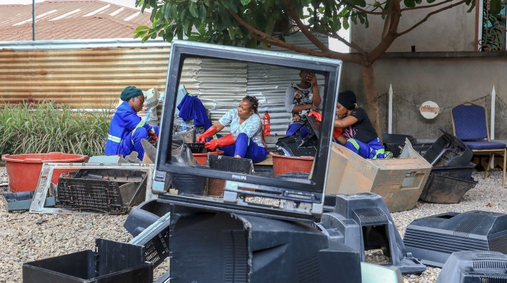 People standing beside a broken down computer 