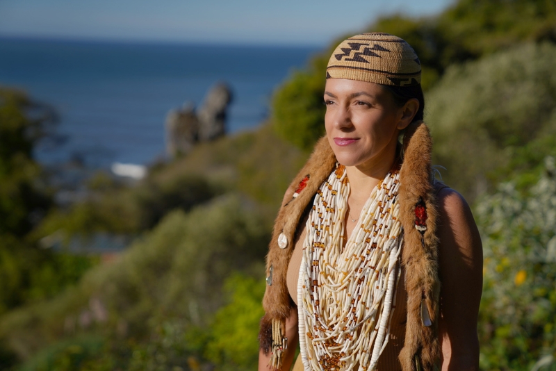 A woman stares off into the distance overlooking the sea
