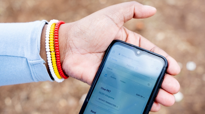 An informal waste picker uses the BanQu App on her cell phone
