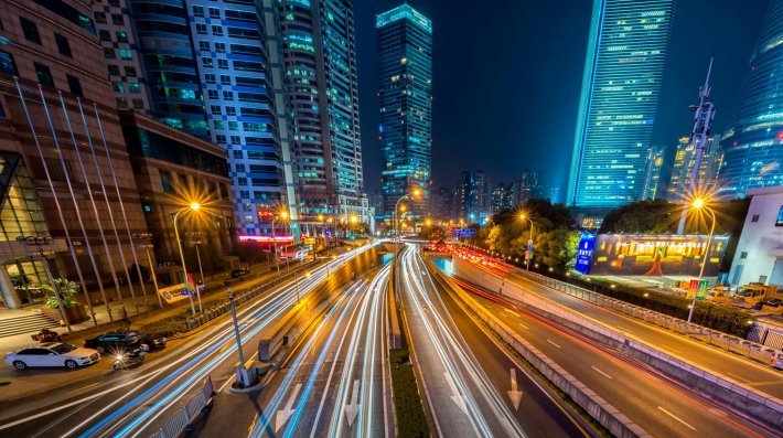 Timelapse Photography of Vehicle on Concrete Road Near in High Rise Building during Nighttime