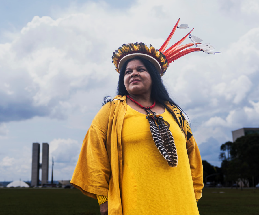 Sonia Guajajara, Brazil’s Minister of Indigenous Peoples, in a traditional headdress gazing into the distance